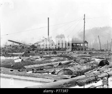 . Linco Log e legname Azienda. Inglese: il laghetto di registro nella parte anteriore del registro Linco e legname Azienda mill vicino Lindberg, Washington. Molti dei registri in flottazione lo stagno in primo piano con il mulino in background. circa 1920 7 Linco Log e legname Azienda 1920 Foto Stock