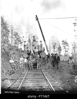 . Inglese: Registrazione equipaggio pianale di carico vagoni ferroviari con motore di asino in background, Goodyear Logging Company, ca. 1919 . Inglese: didascalia sull'immagine: 16 PH Coll 516.1396 Il Goodyear Logging Company è stata in business da ca. 1915 a ca. 1924, con sede a Clallam Bay. Nel 1922, vi erano 175 dipendenti. Clallam Bay è una comunità sulla sponda orientale della baia di Clallam, stretto di Juan de Fuca, nel nord-ovest della contea di Clallam. È stato chiamato con il nome di Baia, che è stato elencato su British Admiralty grafici nel 1846 da Capt. Henry Kellet come Callam, la sua versione anglicizzata del nome indiano. Il nome della baia, un Foto Stock