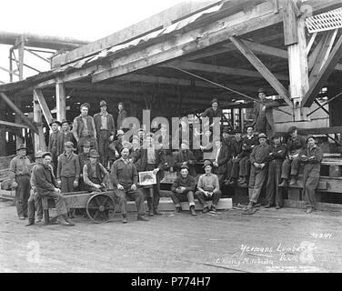 . Inglese: Mill equipaggio, Yeoman legname Azienda, Pe Ell, ca. 1920 . Inglese: didascalia sull'immagine: Yeomans Lumber Co., Pe Ell, Wn. C. Kinsey foto, Seattle. No. 244 PH Coll 516.5265 Antedating la ferrovia, Pe Ell era stata risolta a volte prima del 1890 come una piccola azienda agricola comunitaria, ma la tranquilla vita agricola fu di breve durata. Nel 1892 è venuto il Pacifico settentrionale linea ferroviaria a sud letto, e con essa, nel 1894, la Yeoman legname Azienda mill, prima della stringa di grandi mulini tra Chehalis e South Bend. Situato in una zona agricola e a metà strada sulla linea, Pe Ell prosperò come centro commerciale fo Foto Stock