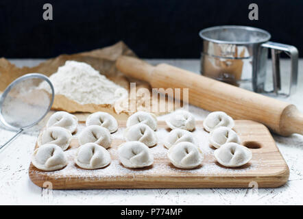 Il processo di realizzazione fatta in casa gnocchi. Raw gnocchi fatti in casa su una tavola di legno. Gnocchi di stampaggio. Foto Stock