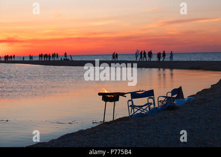 Bellissimo paesaggio marino con la gente a guardare il tramonto sul mare. Foto Stock