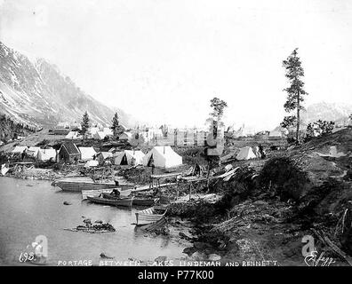 . Inglese: tende, boat building e attività whipsawing, probabilmente sulla riva del lago di Bennett, British Columbia, ca. 1898. Inglese: didascalia sulla immagine: "Portage tra laghi e Lindeman Bennett' n. 693 appare nell'angolo inferiore sinistro . Klondike Gold Rush. Soggetti (LCTGM): laghi e stagni--British Columbia; Tende--British Columbia--Bennett Lago di soggetti (LCSH): Bennett, Lago (a.C.); Boatbuilding--British Columbia--Bennett Lago . circa 1898 13 tende, boat building e attività whipsawing, probabilmente sulla riva del lago di Bennett, British Columbia, ca 1898 (HEGG 620) Foto Stock