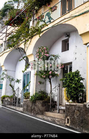 Positano, un villaggio cliffside, strada collinare e casa con oleandri fiore, Costiera Amalfitana, Italia Foto Stock