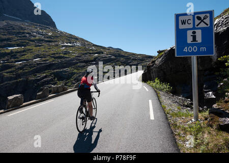 Ciclista femmina salendo la famosa Trollstigen pass, Norvegia Foto Stock