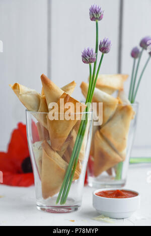 Due bicchieri con triangoli di fillo torte con feta e spinaci Foto Stock