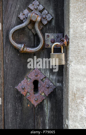 Lucchetto ABUS il bloccaggio di una porta di legno a una pietra del telaio della porta. Foto Stock