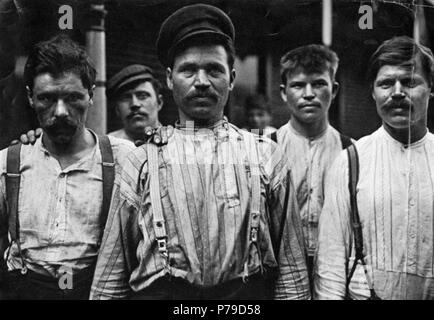 Operai a un russo casa di imbarco da Lewis Hines, Homestead, PA, 1909. Un pioniere nell'uso della telecamera per documentare l'America gli immigrati e i poveri, Lewis Hines realizzato fotografie per il sondaggio di Pittsburgh, un pionieristico studio sociologico della vita industriale nella contea di Allegheny, mentre lavora come fotografo personale per il Russell Sage Foundation. Nel 1909 Hines fotografato questi lavoratori russi al di fuori di un Homestead boarding House nel 1909. Hine davvero interessante immagini facce ha dato a Pittsburgh's lavoratori immigrati e contribuito ad aumentare la consapevolezza del pubblico per la loro situazione. 1909 37 operai presso un cinghiale russo Foto Stock