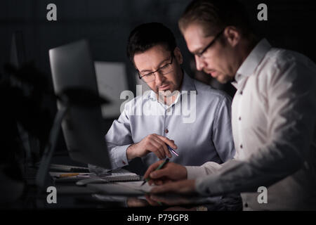 I colleghi di lavoro con documenti in serata. Foto Stock