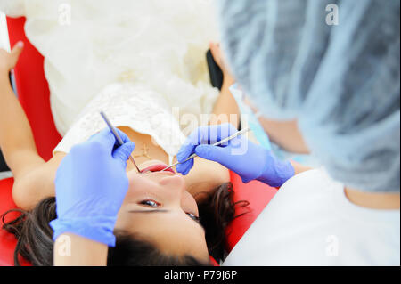 Giovane bella ragazza in studio dentistico. Bambini esamina dentista denti per un bambino. Foto Stock