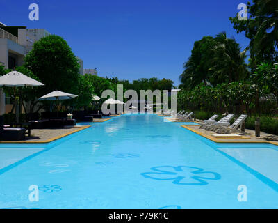 Bella piscina in hotel resort con ombrellone e sedia intorno a. Foto Stock