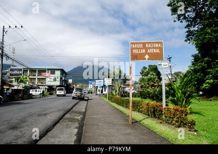 Una vista della strada principale di La Fortuna in Costa Rica. Il Vulcano Arenal può essere visto in lontananza. Foto Stock
