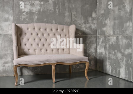 Una sedia morbida su sfondo grigio scuro, la foto in orizzontale Foto Stock