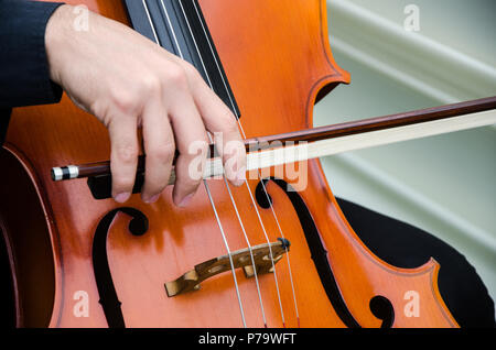 Arte e artista. Giovane uomo elegante violinista suona il violino sul nero. Musica classica. Little Boy strumento musicale. Foto Stock