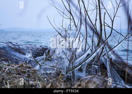 Foresta di inverno con il maestoso fiume al tramonto. Paesaggio invernale con alberi innevati, ghiaccio, bellissimo fiume congelato, boccole nevoso e colorati di cielo nel crepuscolo. Blurre Foto Stock