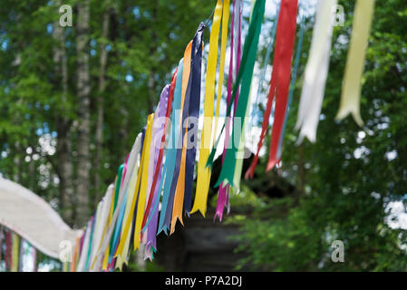 Nastri colorati svolazzanti dal vento in background della foresta. Foto Stock