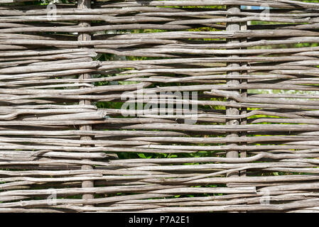 Parete di rametti di salice come sfondo. Rural antica recinzione, realizzata da Willow Tree ramoscelli e rami. Foto Stock