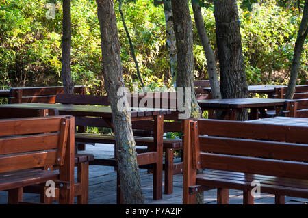 Sedie di legno un tavoli nel ristorante giardino Foto Stock