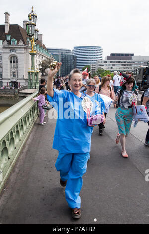 Londra, Regno Unito. 5 Luglio, 2018. Gli attivisti da Docs non poliziotti e il NHS Anti-Swindle Team cross Westminster Bridge dopo la caduta di un banner di lettura "NHS@70: senza frontiere nel settore sanitario" in occasione del settantesimo compleanno del Servizio Sanitario Nazionale. Non Docs poliziotti è un gruppo composto da medici, infermieri, HIV attivisti, gli studenti, gli insegnanti e i laici che credono che la cura della salute è un diritto umano e si sono opposti alle politiche del governo che potrebbe rendere chiunque teme la visita di un medico per motivi di costo o di status di immigrazione. Credito: Mark Kerrison/Alamy Live News Foto Stock