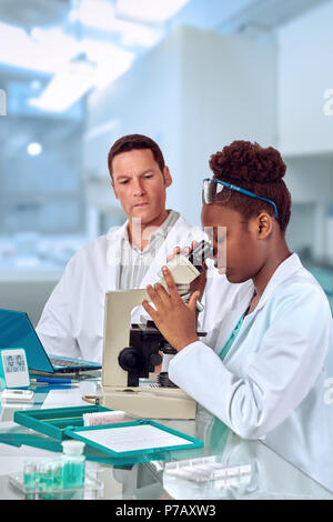 Gli scienziati, senior caucasica e maschio giovane africano femmina, lavorare con un microscopio in laboratorio di ricerca. DOF poco profondo, concentrarsi sul volto della donna Foto Stock