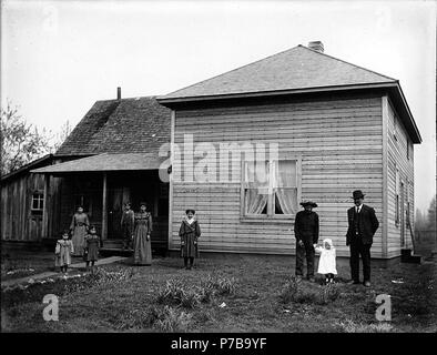 . Inglese: Homestead mostra famiglia in cantiere al di fuori di casa, Washington, ca. 1906. Inglese: mostra due uomini, tre donne e tre bambini e il bambino in piedi nella parte anteriore del telaio di legno house . Sul manicotto del negativo: residenze. Telaio normale casa soggetti (LCTGM): Homesteading--Washington (stato); abitazioni--Washington (stato); famiglie--Washington (stato); Gruppo ritratti . circa 1906 45 Homestead mostra famiglia in cantiere al di fuori di casa, Washington, ca 1906 bar (247) Foto Stock