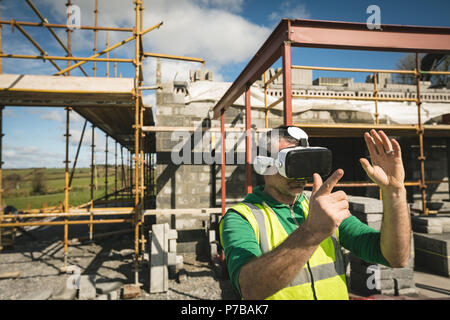 Ingegnere sperimentando VR cuffia sul sito di costruzione Foto Stock