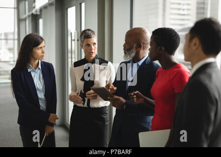 Gruppo serio di imprenditori aventi una discussione su tablet Foto Stock
