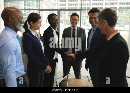 Gli imprenditori si stringono la mano in ufficio Foto Stock