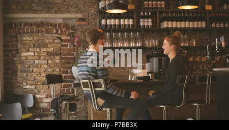 Matura un caffè mentre è seduto al banco bar Foto Stock