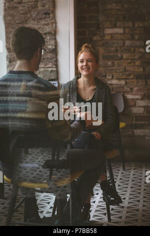 Paio di chattare in un caffè presso la caffetteria Foto Stock