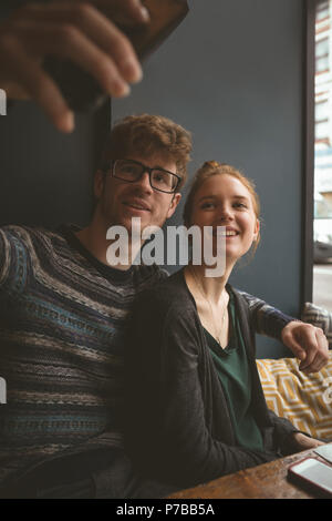 Giovane prendendo un selfie in cafe Foto Stock