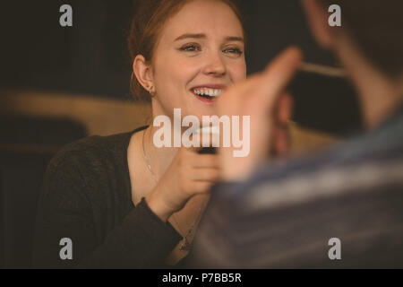 Coppia sorridente di parlarsi al ristorante Foto Stock