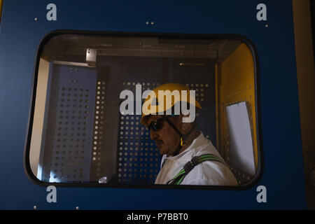Ingegnere in piedi all'interno di ascensore di servizio Foto Stock