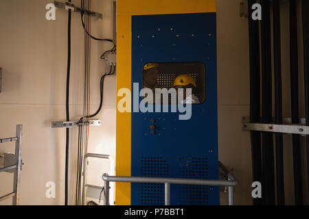 Ingegnere in piedi all'interno di ascensore di servizio Foto Stock