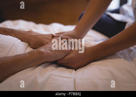 Fisioterapista tenendo la mano di una donna senior Foto Stock