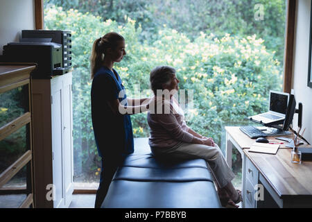 Fisioterapista dando un massaggio alla donna senior Foto Stock