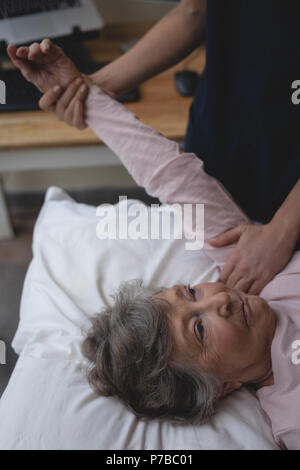 Fisioterapista dando una mano al massaggio donna senior Foto Stock