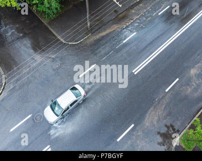 Corse in auto attraverso strade allagate in giorno piovoso. foto aerea Foto Stock