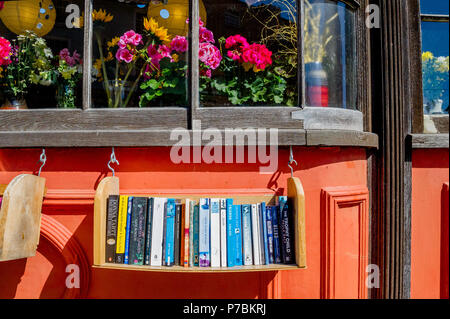 Libri per la vendita su un libro appesi ripiano. Foto Stock