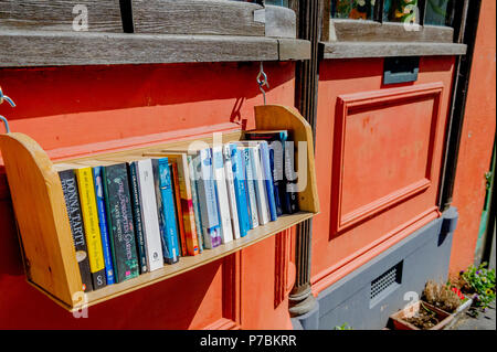 Libri per la vendita su un libro appesi ripiano. Foto Stock