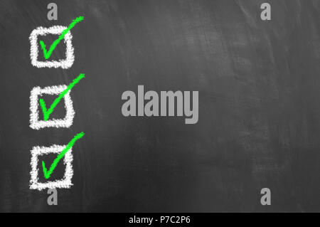 Tre verdi contrassegnate le caselle di controllo disegno sulla lavagna o lavagna come fare il controllo di qualità elenco degli obiettivi concetto con vuoto lo spazio di copia Foto Stock