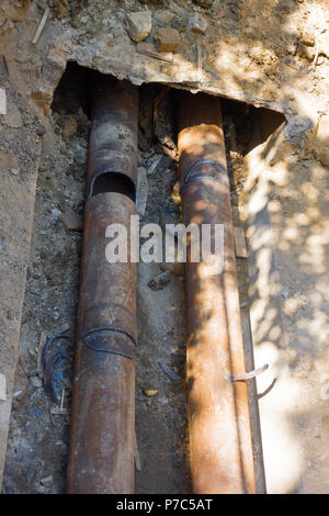 Metallo due tubi saldati togather laici nel terreno Foto Stock