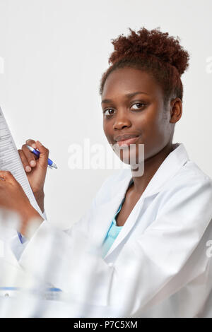 Scienziato africani, medico o o studente laureato. Fiducioso giovane donna indossa camice detiene una penna e un questionario, a fuoco gli occhi Foto Stock