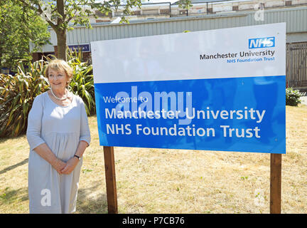 Giugno Rosen, sorge accanto a un segno per Manchester University NHS Foundation Trust a Trafford General Hospital di Manchester per contrassegnare il settantesimo anniversario dell'NHS. Foto Stock