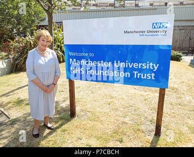 Giugno Rosen, sorge accanto a un segno per Manchester University NHS Foundation Trust a Trafford General Hospital di Manchester per contrassegnare il settantesimo anniversario dell'NHS. Foto Stock