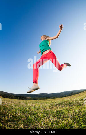 Ragazza saltando in natura, immagine ripresa con lente fish-eye Foto Stock