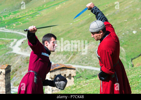 Il pugnale di spettacolo di combattimento da due uomini georgiano di un gruppo folcloristico, Ushguli, regione di Svaneti, Georgia Foto Stock