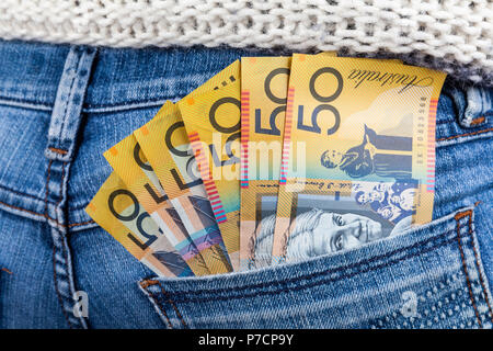50 Aud fatture in forma ventilatore posto in jeans femminili tasca posteriore closeup - Salario minimo concetto Foto Stock