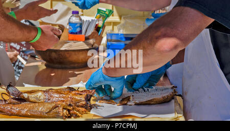 Dinnet FESTIVAL ABERDEENSHIRE SCOZIA Arbroath Smokies eglefino per preparare la rimozione della spina dorsale dall'affumicato e pesce cotto Foto Stock