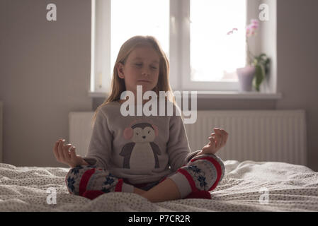 Ragazza di eseguire lo yoga in camera da letto Foto Stock