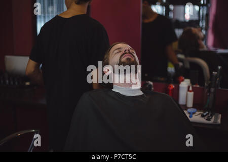 L'uomo ottenendo la sua barba rasata con trimmer Foto Stock